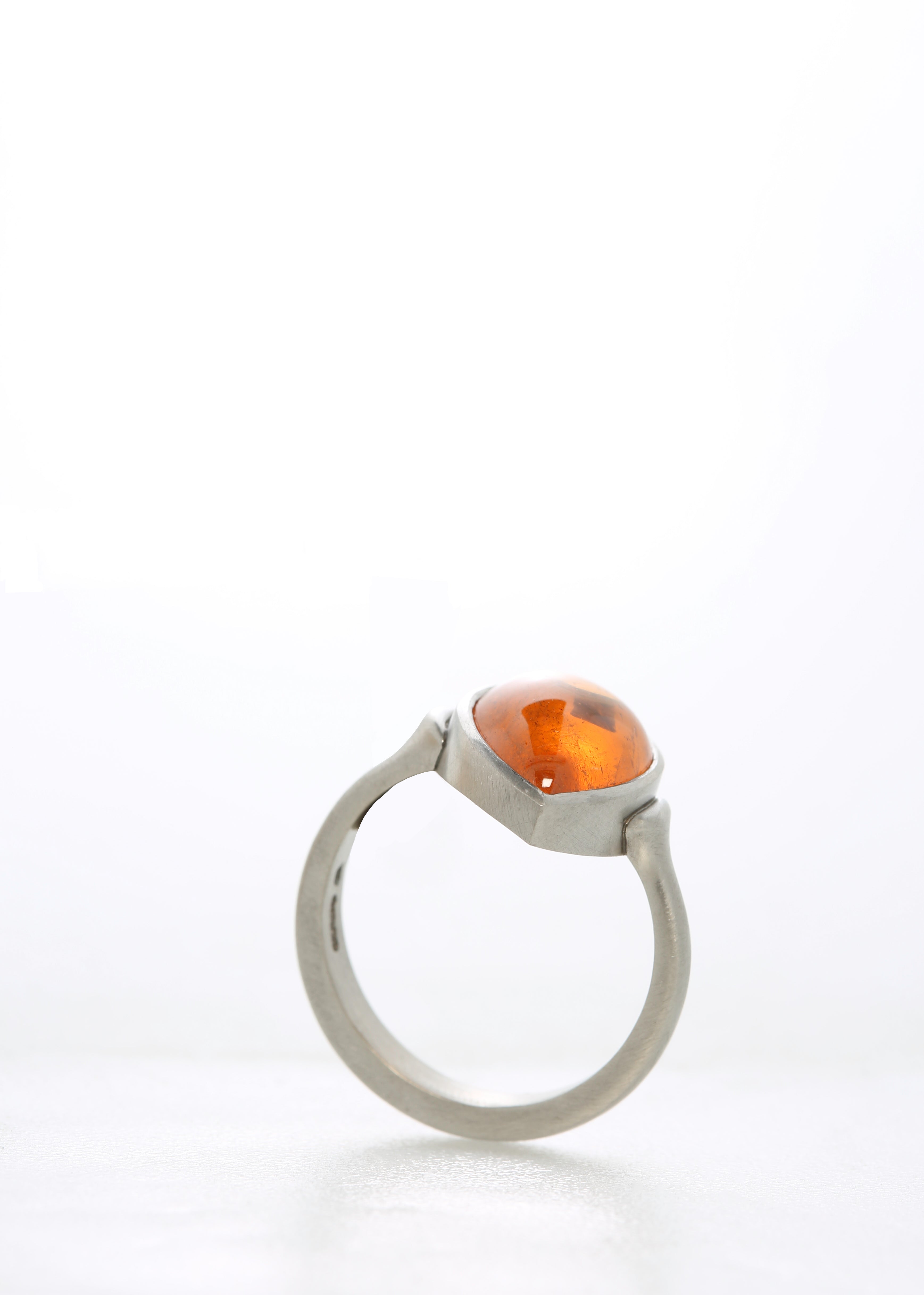 Mandarin garnet cabochon in platinum ring.